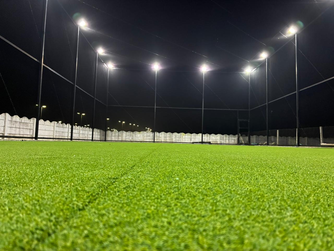 Floodlit turf viewed from the goal line