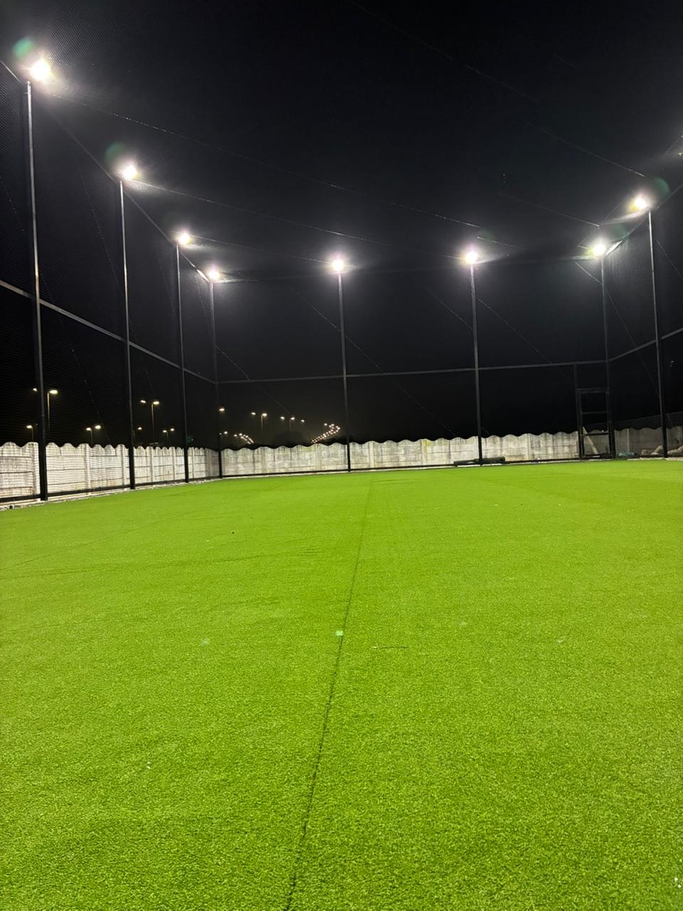 Turf surface with perimeter netting at night