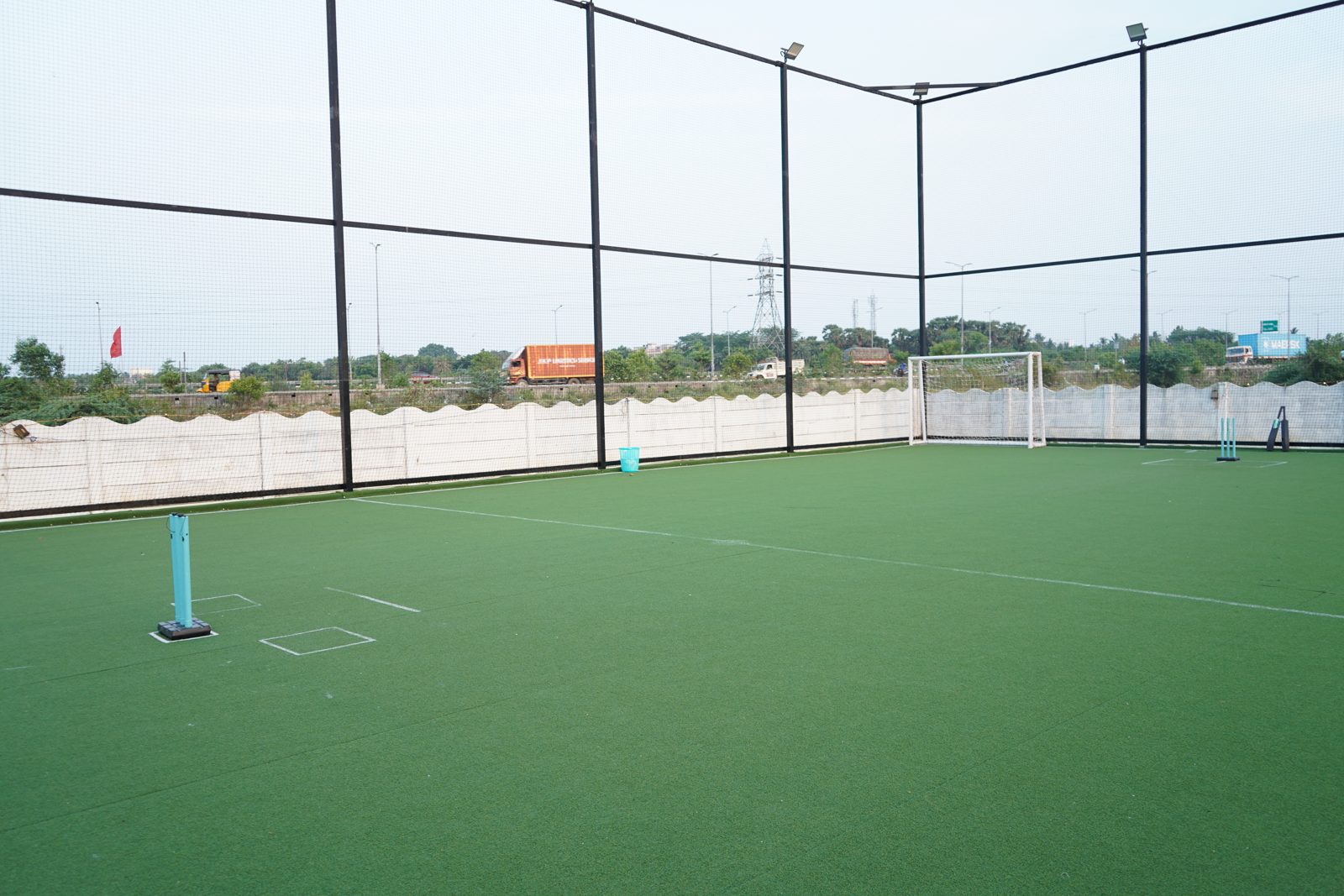 The turf in daylight with football goal and cricket stumps